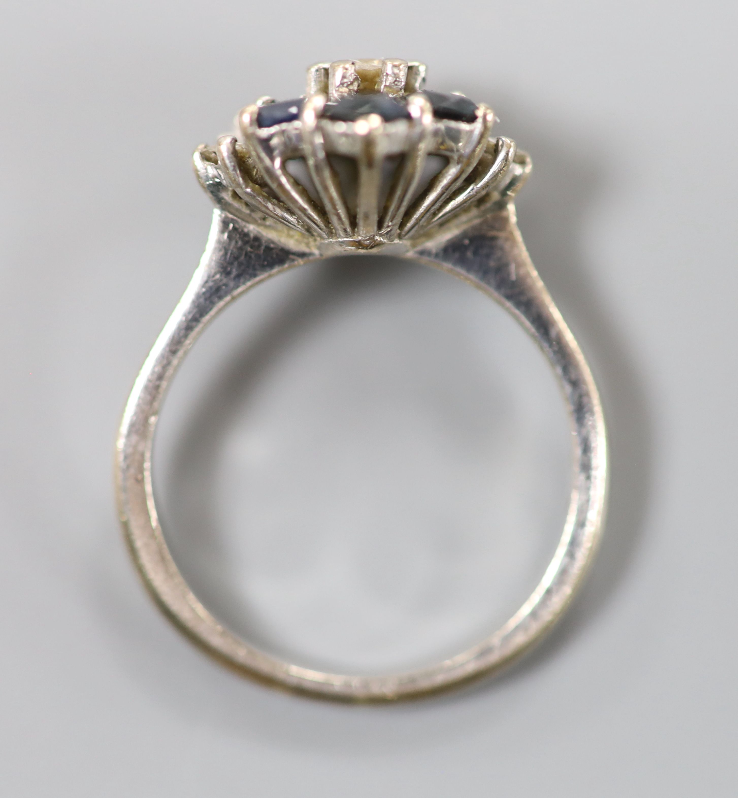 A white metal (stamped 18ct), sapphire and diamond cluster ring, size M, gross 4.2 grams.